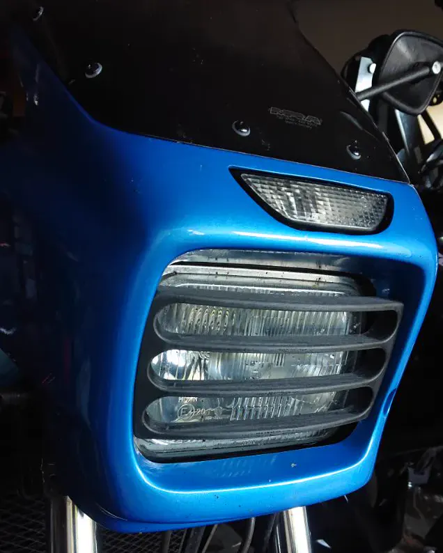 Grille de phare imprimée en 3D, peinte en bleu, montée sur l'avant d'une moto